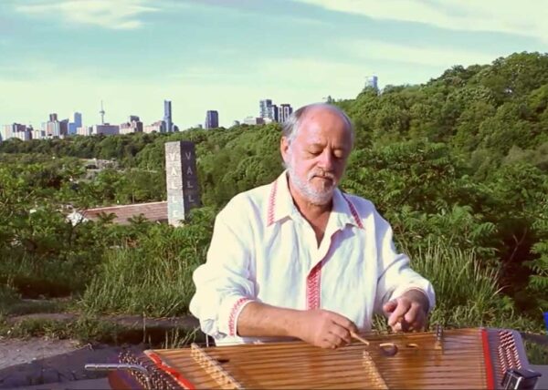 Vladimir Gorodkin - Music & Promo Video (2:03) showing Vladimir playing folk instrument called Tsimbaly with green trees and silhouette of Toronto